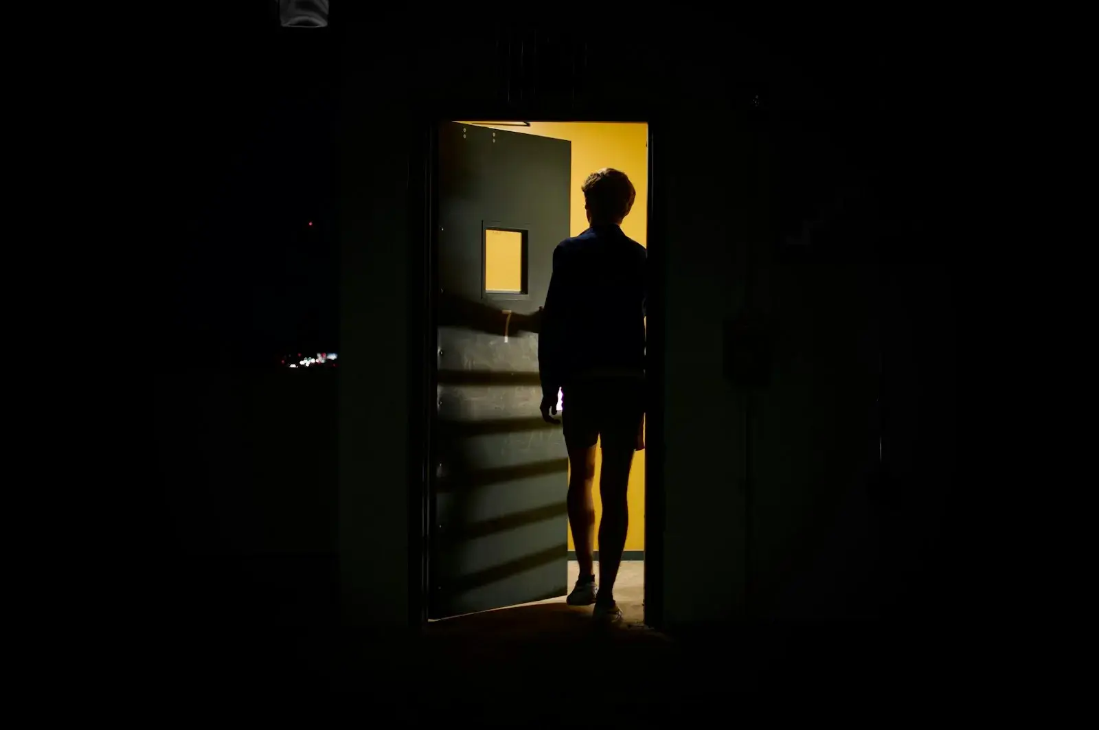 Ein Mann steht in einer offenen Tür und schaut nach draußen